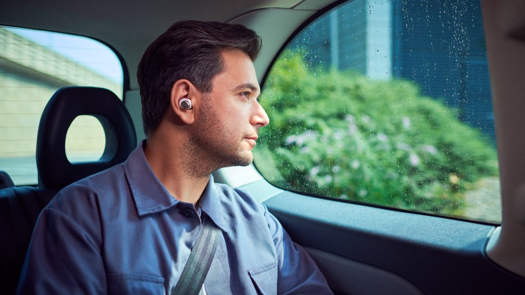 Man relaxes in car wearing Bowers & Wilkins PI7 earbuds