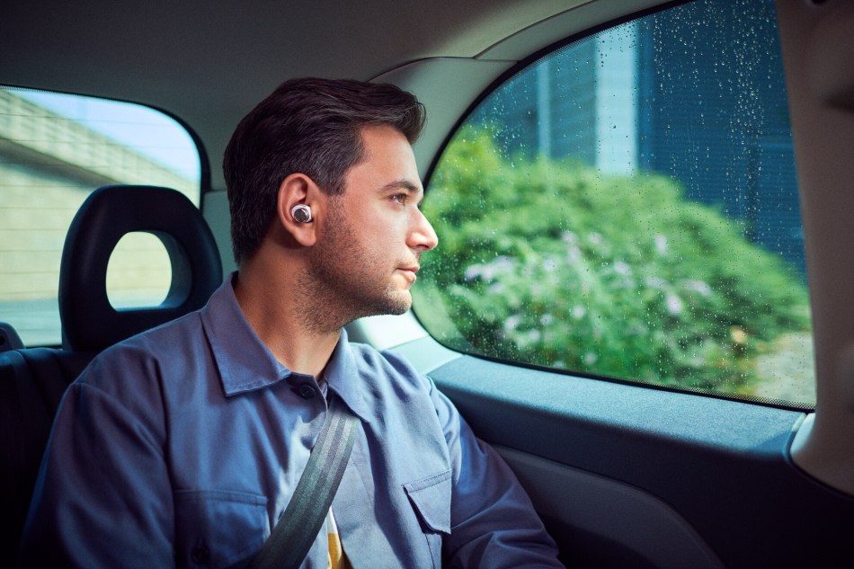 Man relaxes in car wearing Bowers & Wilkins PI7 earbuds
