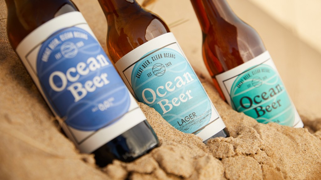 Three bottles of Ocean Beer in the sand on a beach