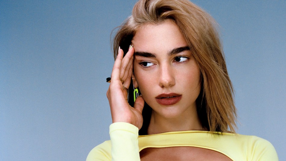 Singer Dua Lipa poses in a yellow dress for a promotional image