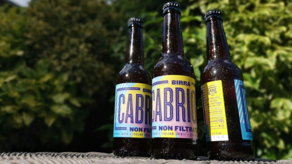 Three bottles of Birra Cabriole lager in a garden setting
