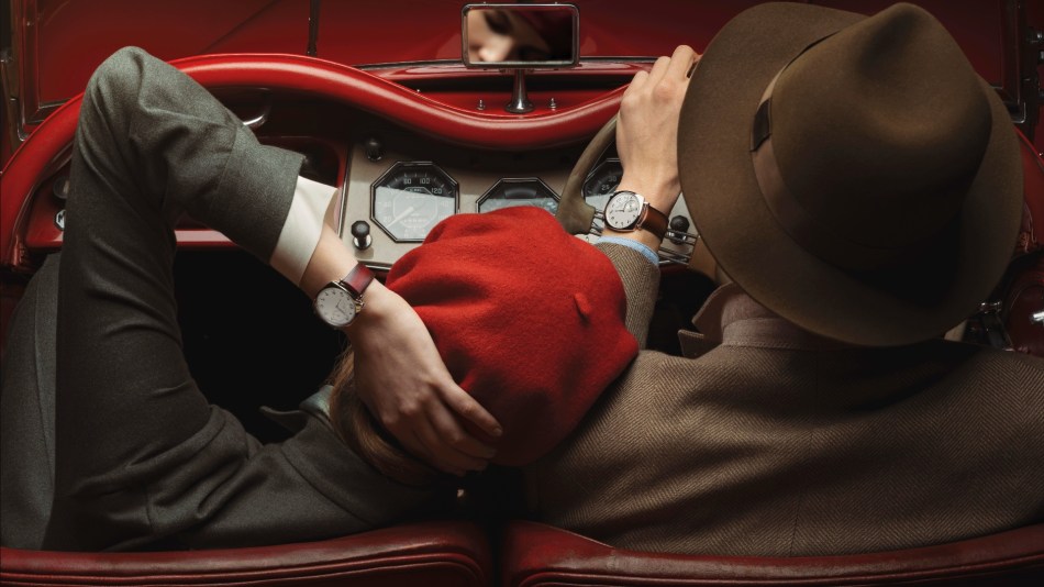 A couple in a classic car show off their luxury watches