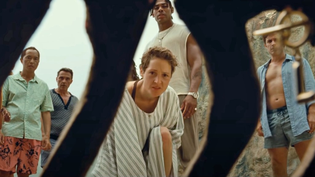 The cast of Old are framed by the ribs of a corpse on a beach in Old