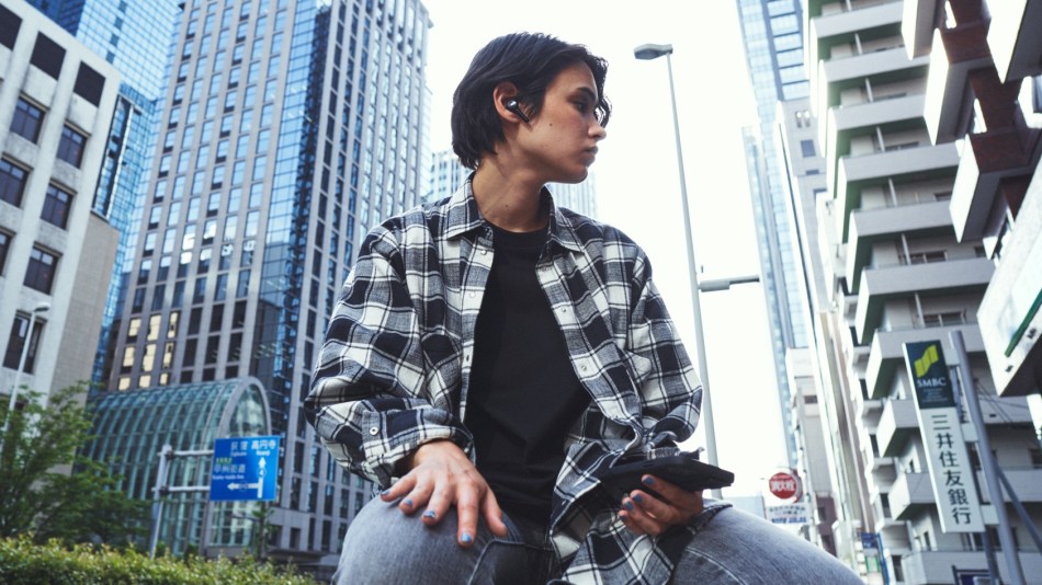 A young man wearing Diesel earbuds out in the street