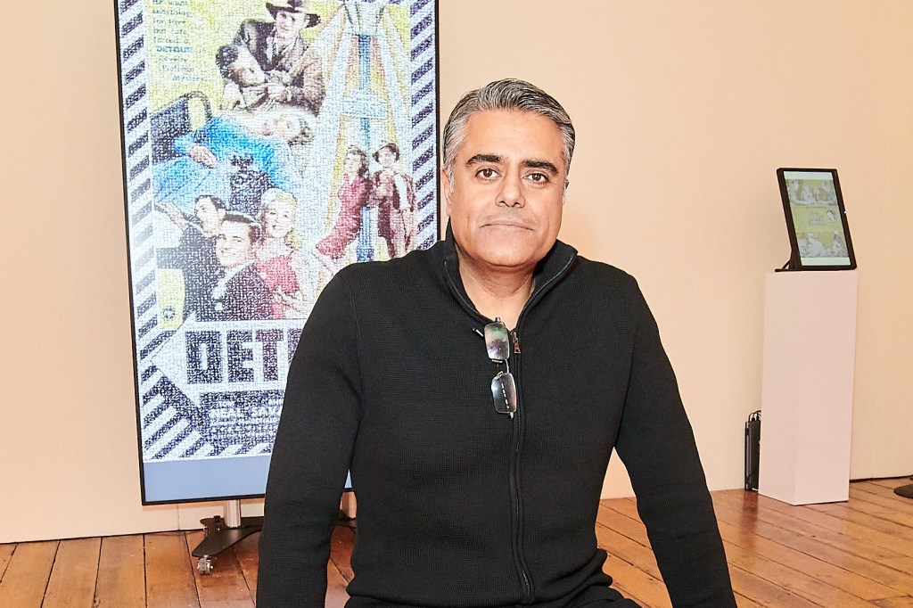 Cineframes Sanjay Wadhwani poses in from of an NFT screen