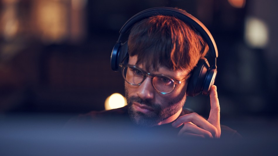 Gamer wears Beoplay Portal PC PS headphones
