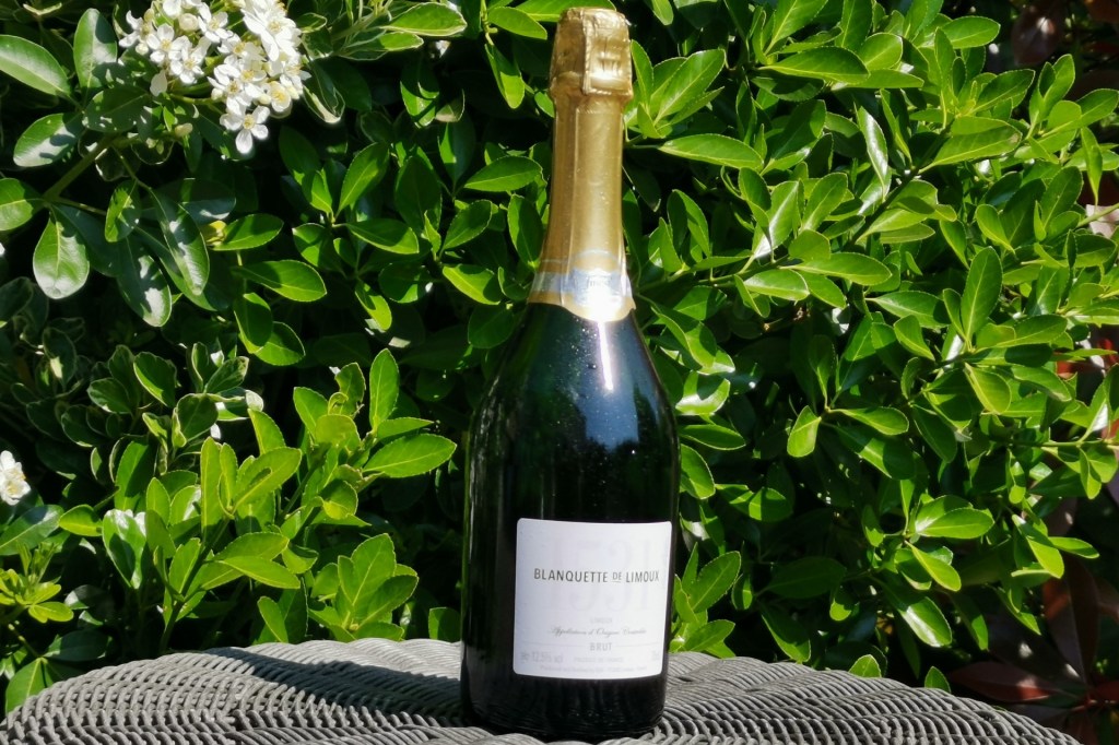 A bottle of Blanquette de Limoux against a backdrop of green leaves