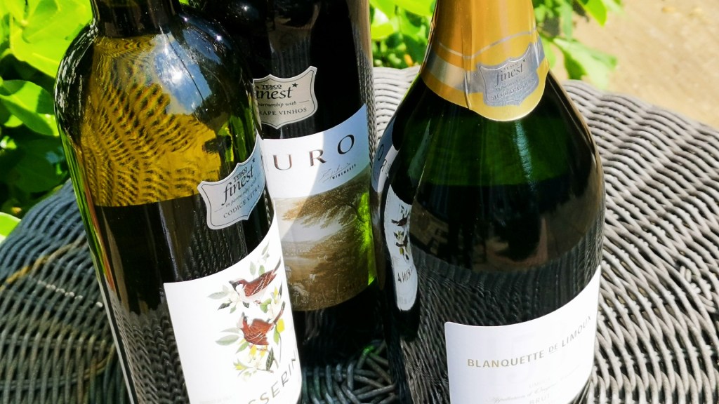 A trio of wines from Tesco show sit on a garden table in the sun