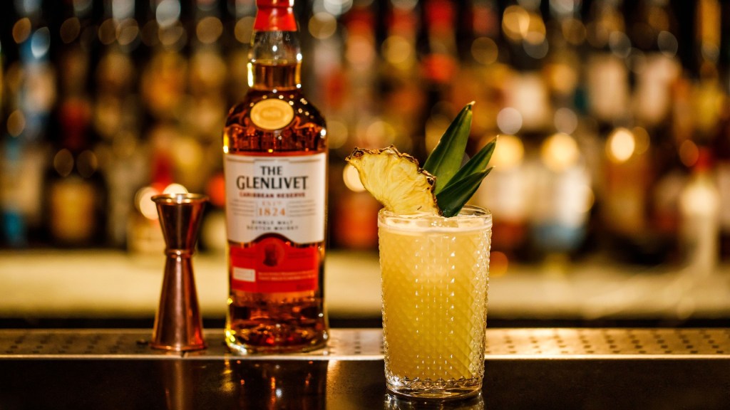 A cocktail stands before a bottle of The Glenlivet Caribbean Reserve