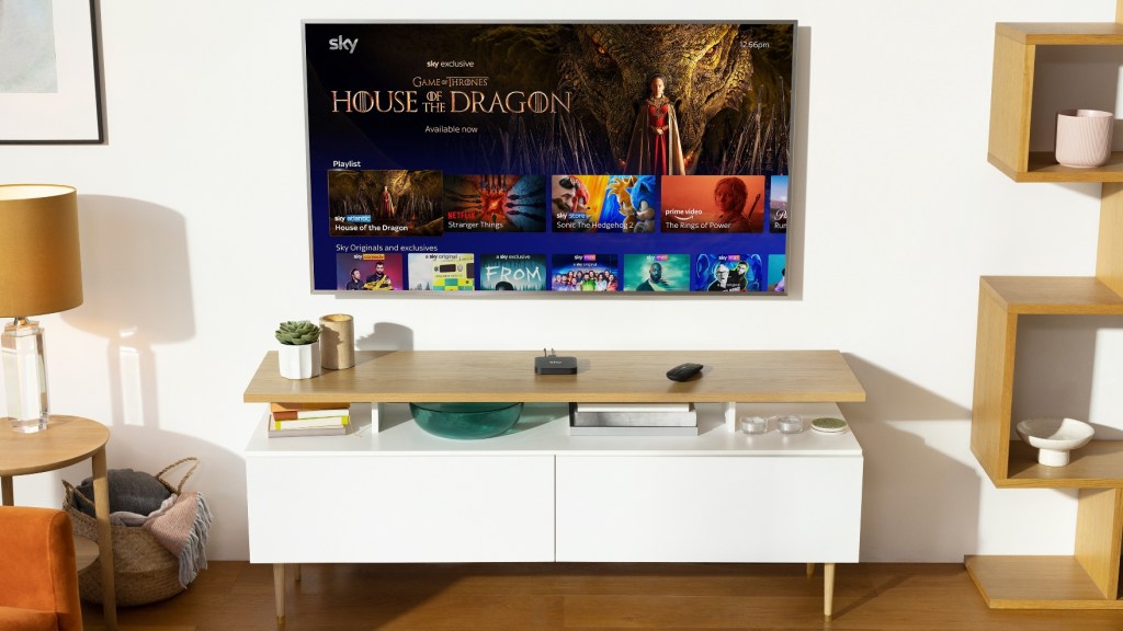 A tiny Sky Stream box sits beneath a giant Tv with the Sky Glass UI showing House of the Dragon