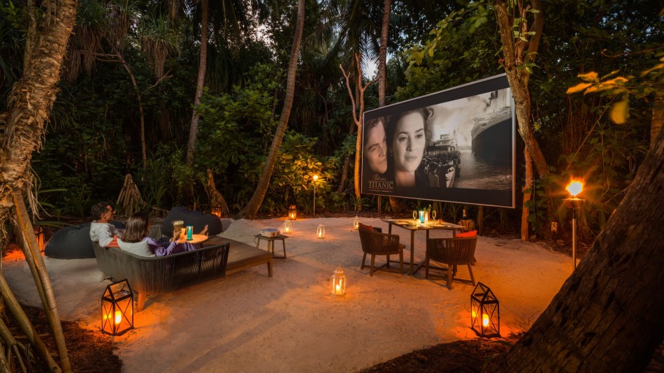 The Jungle setting at Vakkaru Maldives, with a couple kicking back to watch Titanic