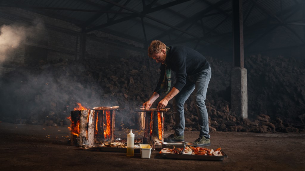 Chef Tom Aitkens cooks on a rough hewn log fire