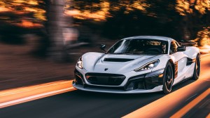 The fully electric Rimac Nevera supercar speeding along a country road