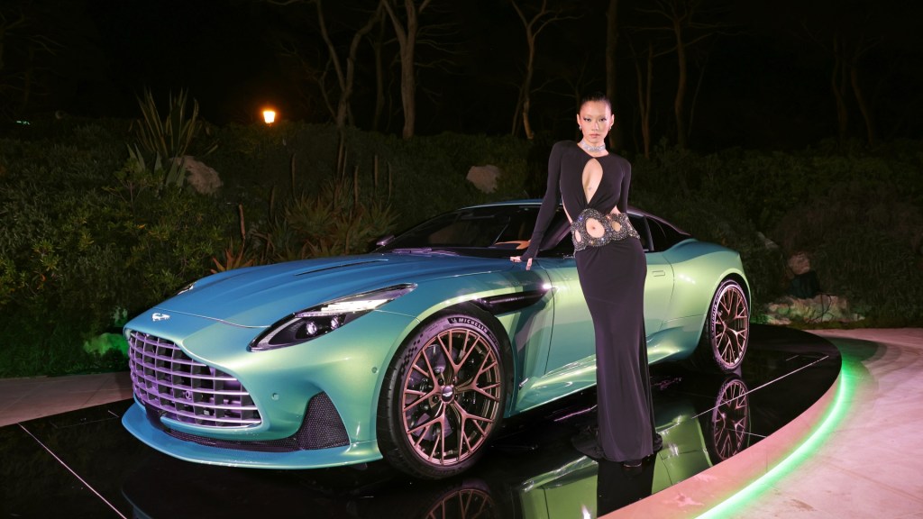 Aston Martin DB12 unveiled at Cannes with model posing