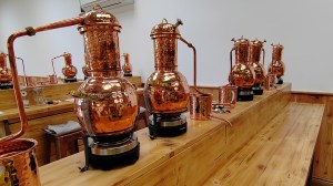 Copper stills on a long work bench at Ramsbury Estate Gin School