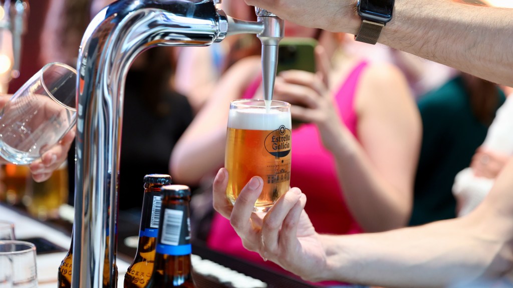 A glass of Estrella Galicia is poured with a perfect creamy head