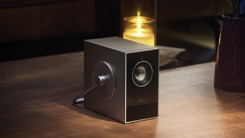 An LG CineBeam Qube video projector sits alongside a candle