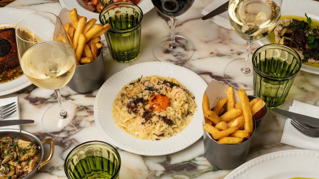 Different dishes and fries on the table at Nessa restaurant in Soho, London
