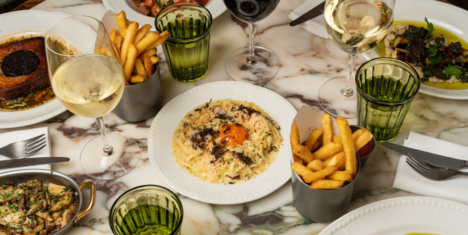 Different dishes and fries on the table at Nessa restaurant in Soho, London