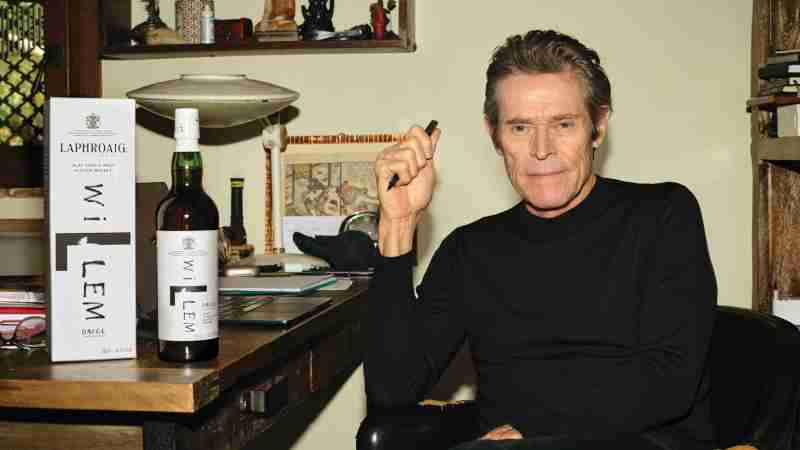 Willem Dafoe at a table with Laphroaig
