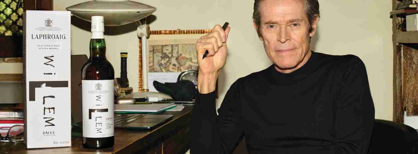 Willem Dafoe at a table with Laphroaig