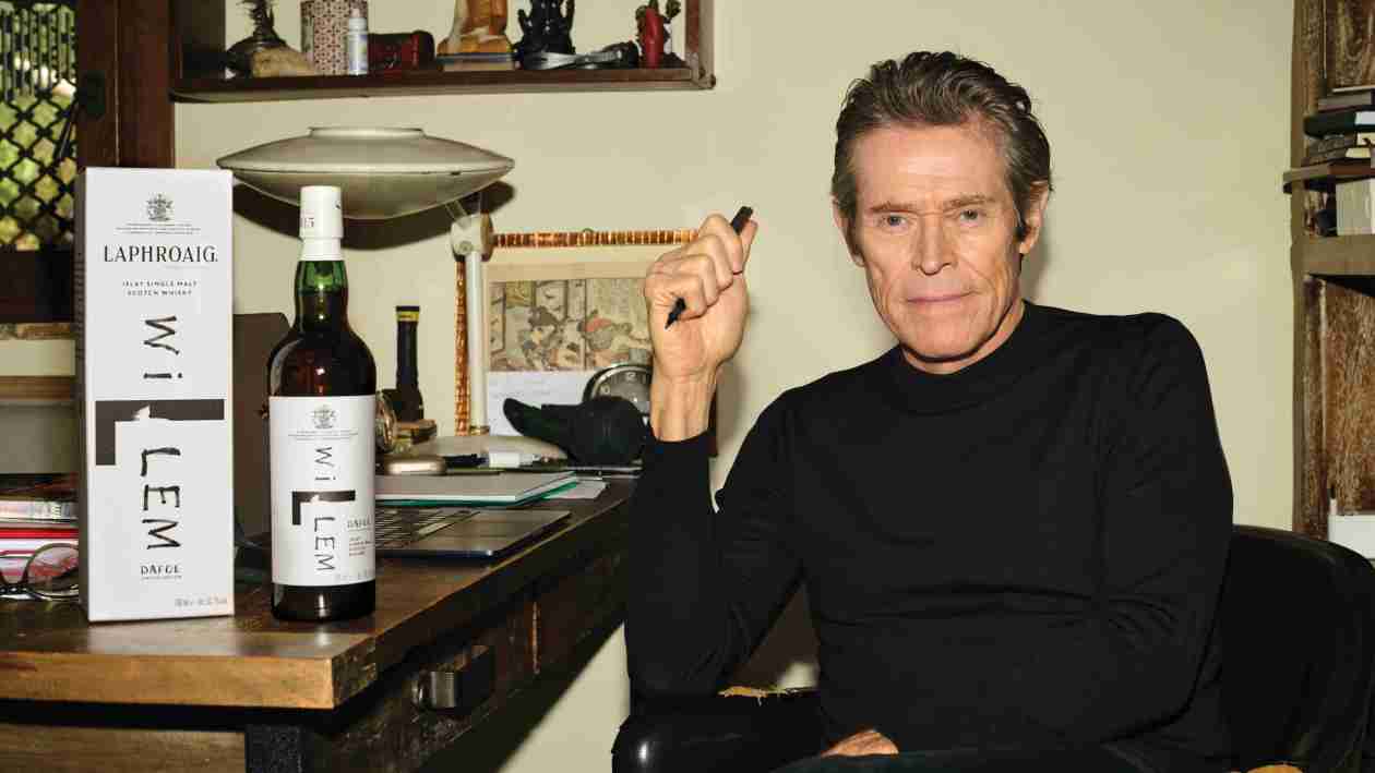 Willem Dafoe at a table with Laphroaig