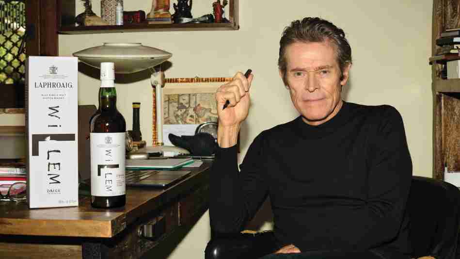 Willem Dafoe at a table with Laphroaig