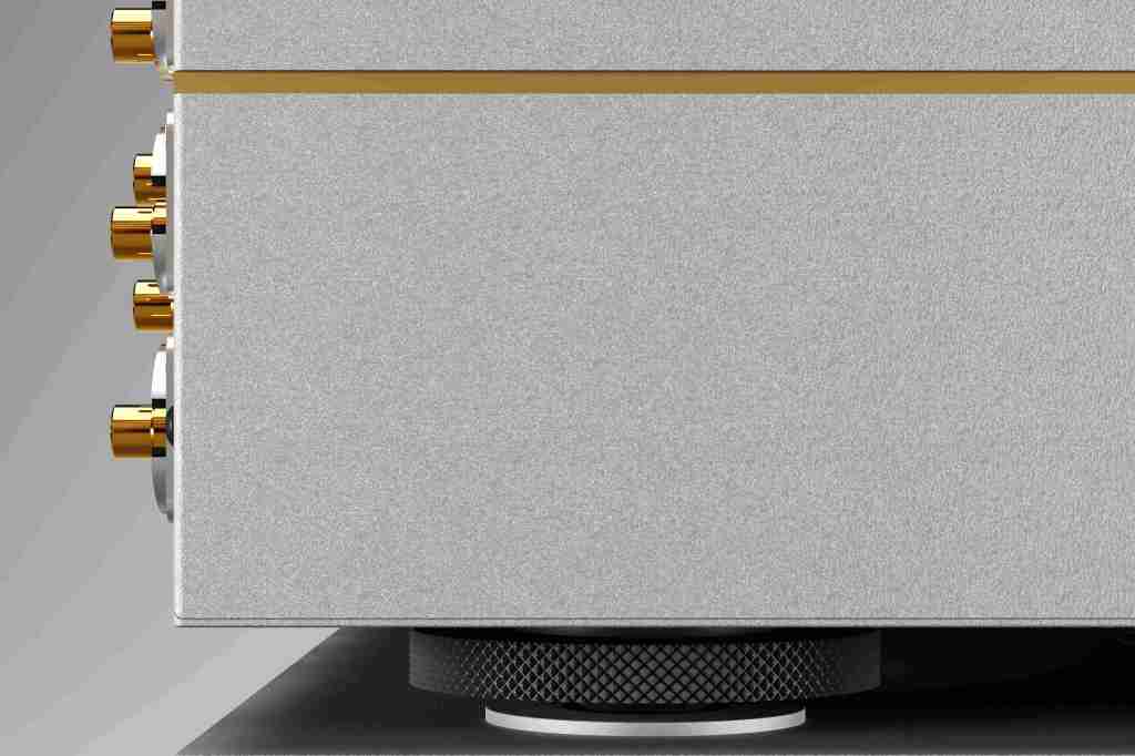 Close-up of a silver audio amplifier featuring gold-plated connectors and a textured volume knob at the base.