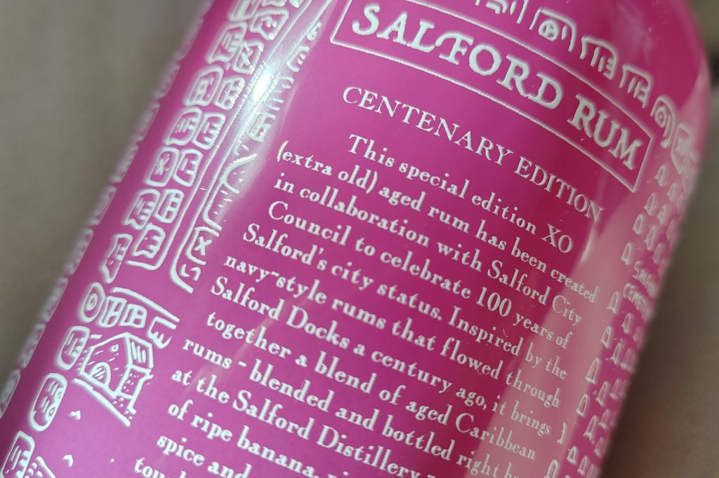 Close-up of a bottle label for Salford Rum, featuring the text 'Centenary Edition' along with a description of the rum's special edition created in collaboration with Salford City Council to celebrate its 100-year status.